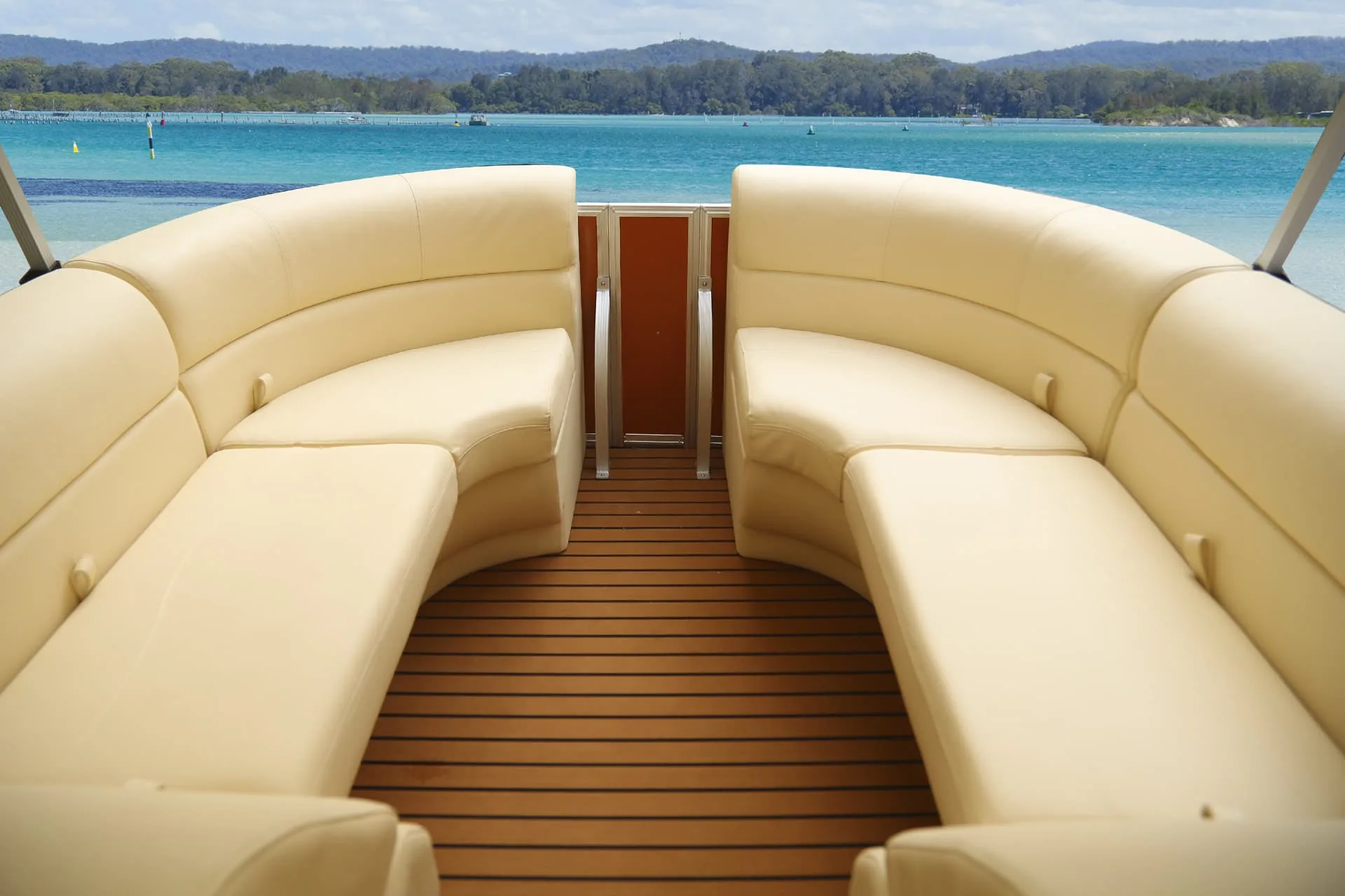 Cream pontoon lounge seating alongside a teak-style deck