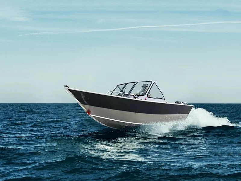 Shelter 21 aluminum fishing boat with a soft top underway, seen from the bow quarter