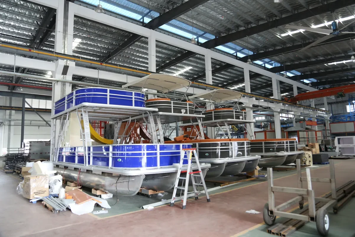 Blue and black double-deck pontoon boats with canopy tops inside an assembly hall
